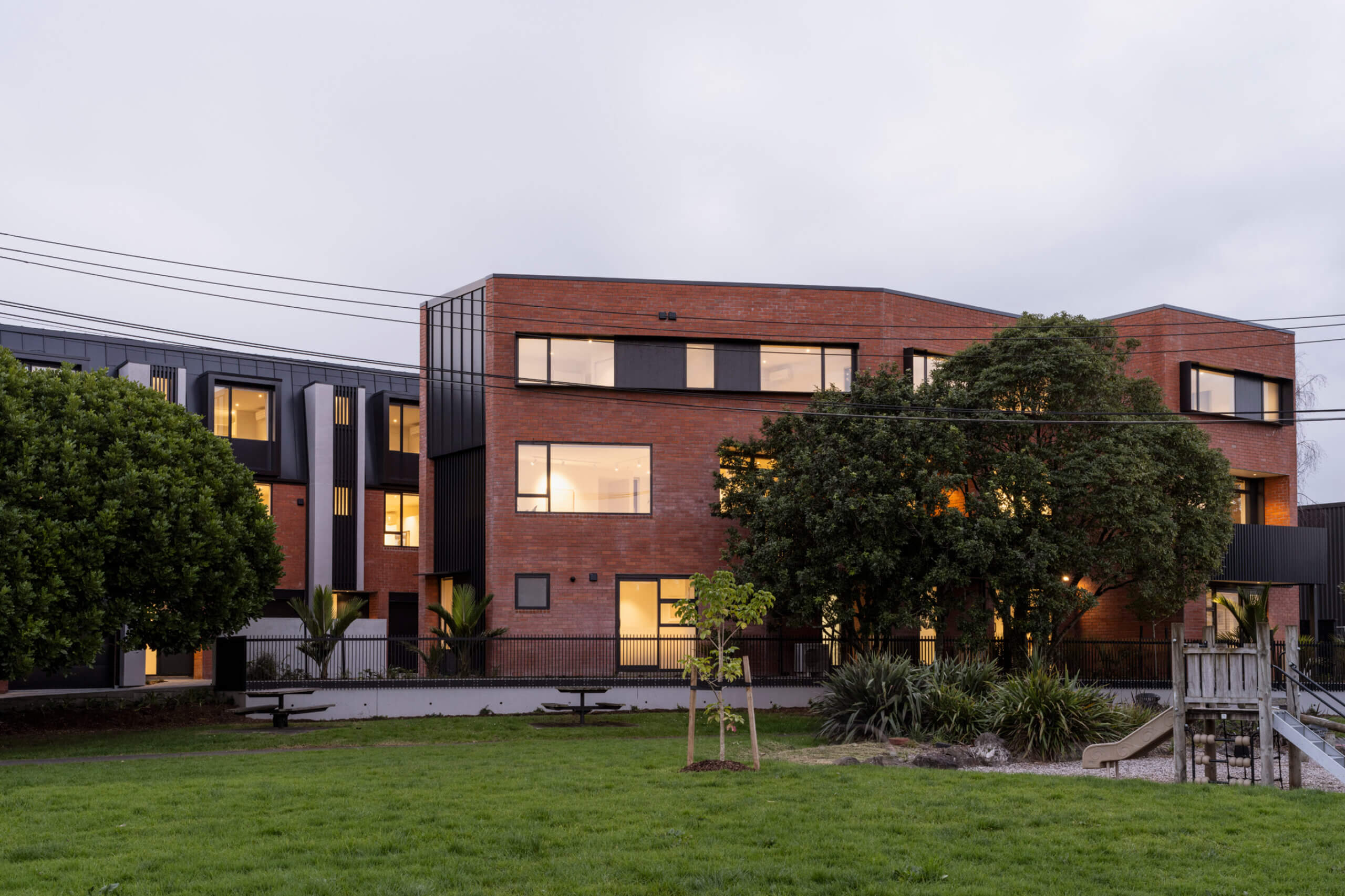 Sainsbury Reserve looking at the Mesa Morningside Auckland townhouses crafted in clay brick and black metal