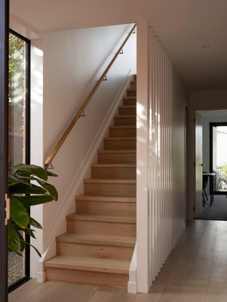 Light filled entrance way with wooden stairs at Mesa Morningside Auckland townhouses